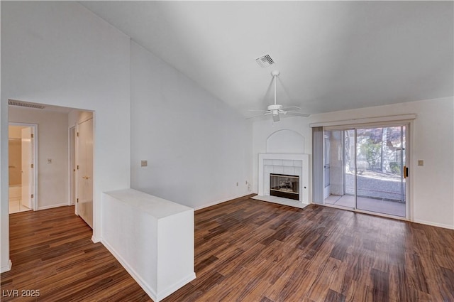 unfurnished living room with a tiled fireplace, ceiling fan, high vaulted ceiling, and dark hardwood / wood-style flooring