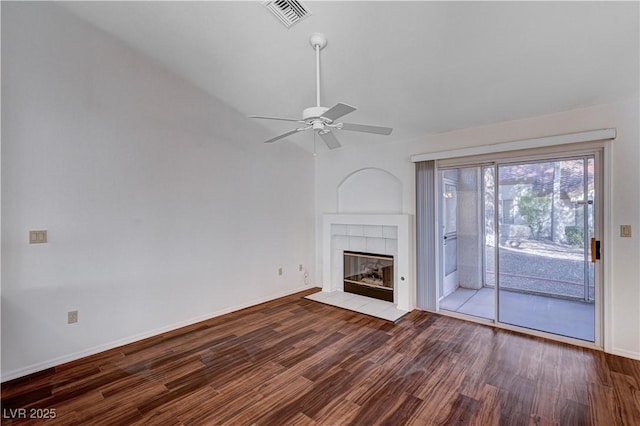 unfurnished living room featuring a tiled fireplace, hardwood / wood-style flooring, and ceiling fan