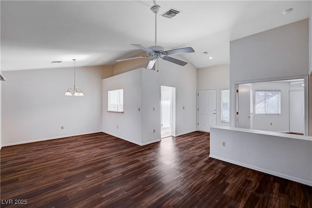 unfurnished living room with dark wood-type flooring, lofted ceiling, plenty of natural light, and ceiling fan with notable chandelier