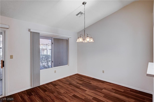 empty room featuring dark hardwood / wood-style flooring, vaulted ceiling, and an inviting chandelier