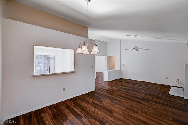 interior space featuring vaulted ceiling, ceiling fan with notable chandelier, and dark hardwood / wood-style flooring