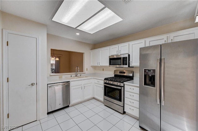 kitchen with white cabinetry, sink, stainless steel appliances, and light tile patterned flooring