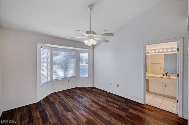 unfurnished room featuring ceiling fan, lofted ceiling, dark hardwood / wood-style flooring, and sink