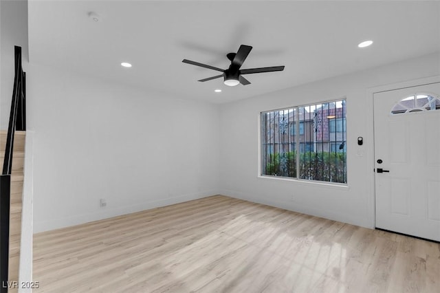 foyer entrance with ceiling fan and light hardwood / wood-style floors