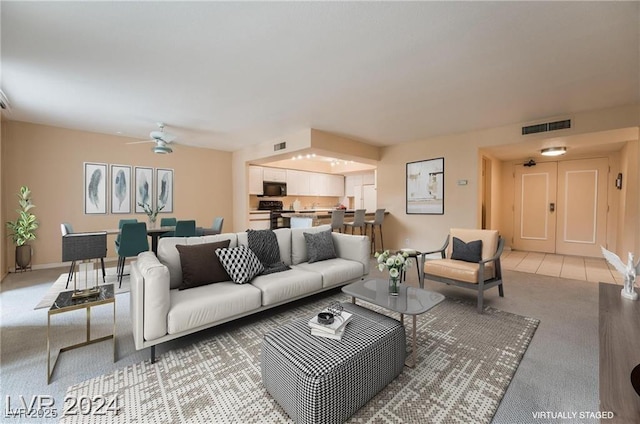 carpeted living room featuring ceiling fan