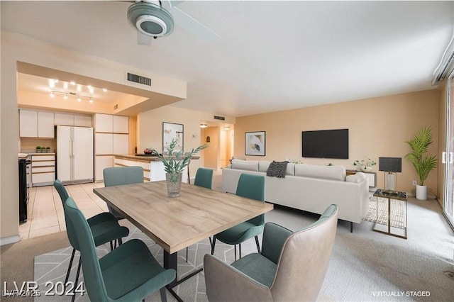 carpeted dining space with rail lighting