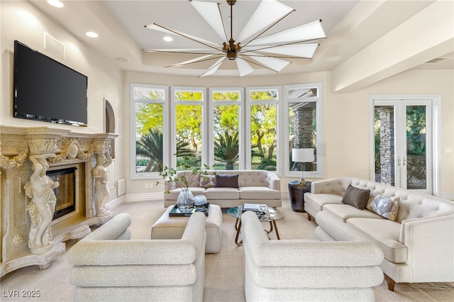 living room with french doors, a stone fireplace, and carpet floors