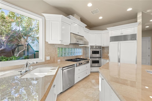 kitchen featuring appliances with stainless steel finishes, white cabinets, and light stone counters