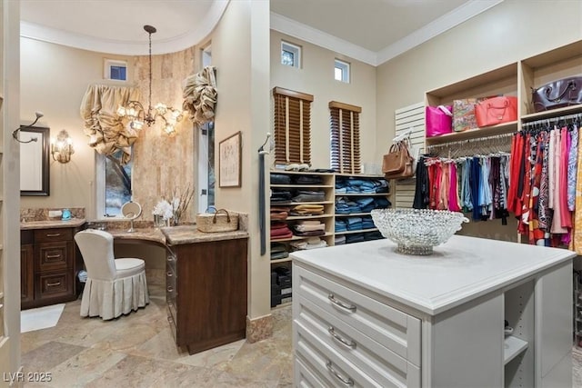 spacious closet featuring built in desk and a notable chandelier