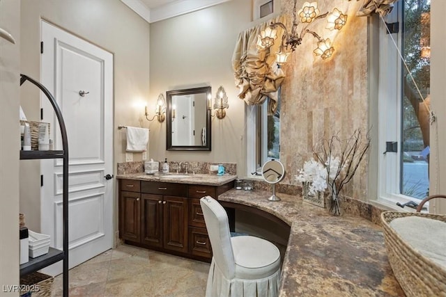 bathroom featuring vanity, a healthy amount of sunlight, and ornamental molding