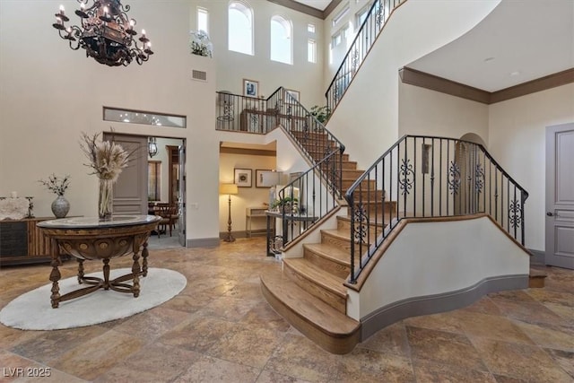 stairs featuring ornamental molding and an inviting chandelier