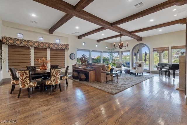 living room featuring beamed ceiling, hardwood / wood-style floors, and a notable chandelier