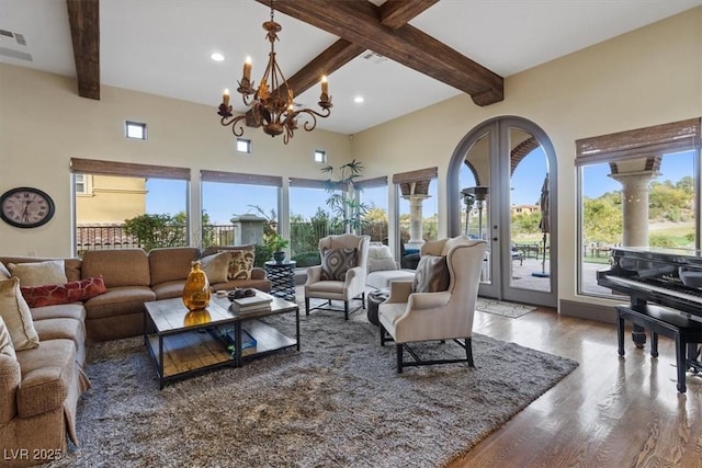 living room with hardwood / wood-style flooring, beam ceiling, french doors, and a notable chandelier