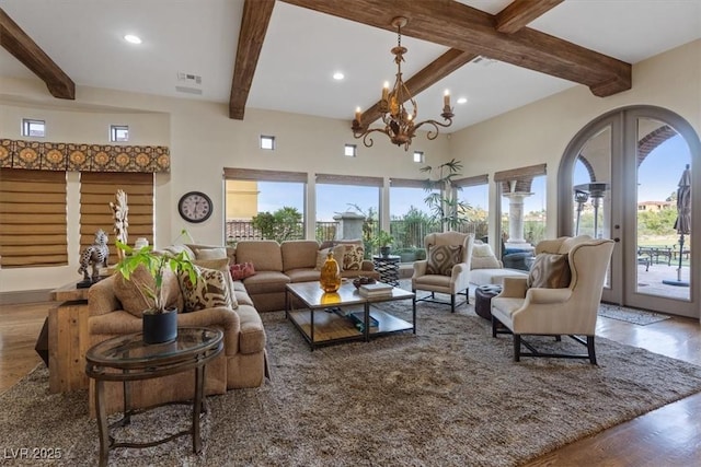 living room featuring french doors, wood-type flooring, beam ceiling, and a notable chandelier