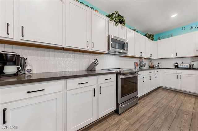 kitchen featuring white cabinetry, appliances with stainless steel finishes, and decorative backsplash