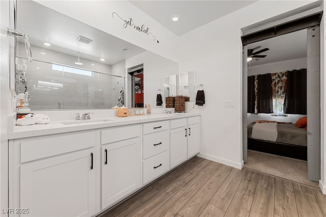 bathroom with hardwood / wood-style flooring, vanity, ceiling fan, and a shower with shower door