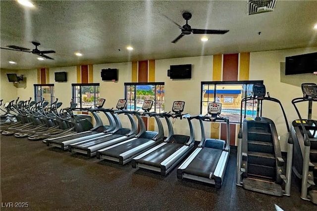 gym featuring ceiling fan and a textured ceiling