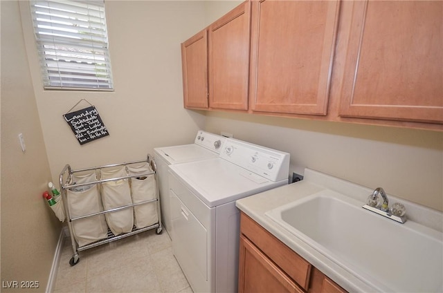 clothes washing area featuring cabinets, sink, light tile patterned floors, and independent washer and dryer