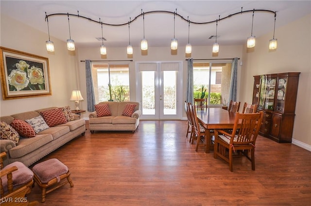 dining room with dark wood-type flooring, a wealth of natural light, and french doors