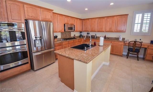 kitchen featuring sink, appliances with stainless steel finishes, a kitchen island with sink, light stone countertops, and light tile patterned flooring