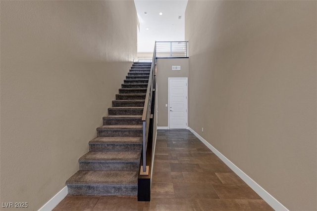 staircase featuring a high ceiling