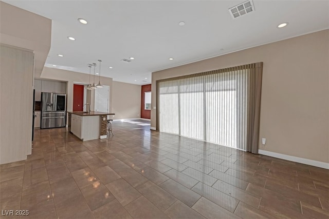 unfurnished living room featuring sink and dark tile patterned floors