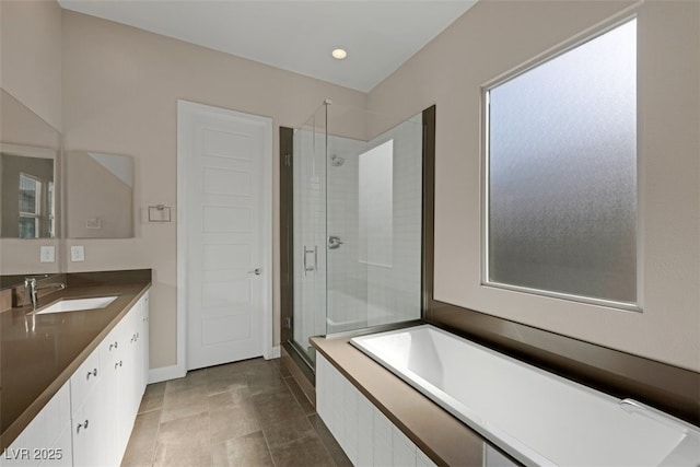 bathroom featuring shower with separate bathtub and vanity