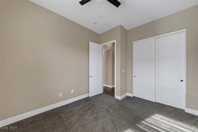 unfurnished bedroom with ceiling fan, dark carpet, and a closet