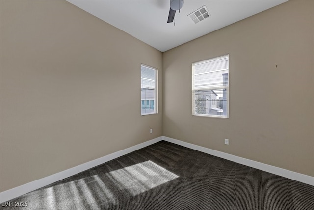 spare room with ceiling fan and dark colored carpet