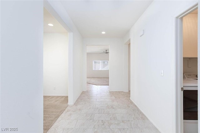 hallway with light carpet and washer / clothes dryer