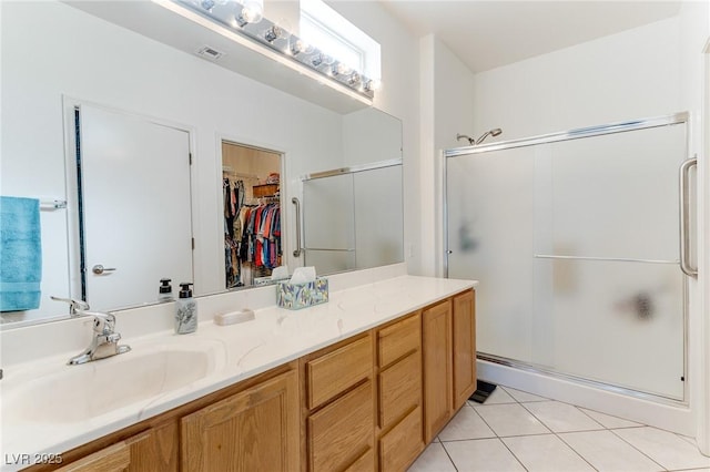 bathroom with vanity, a shower with shower door, and tile patterned flooring