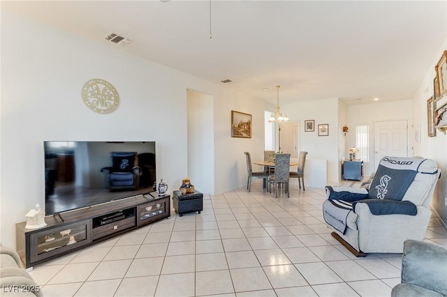 tiled living room with a notable chandelier