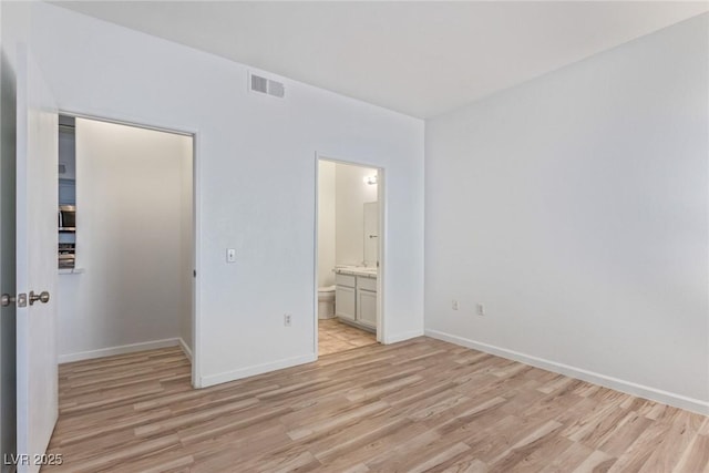 unfurnished bedroom with light hardwood / wood-style floors and ensuite bathroom