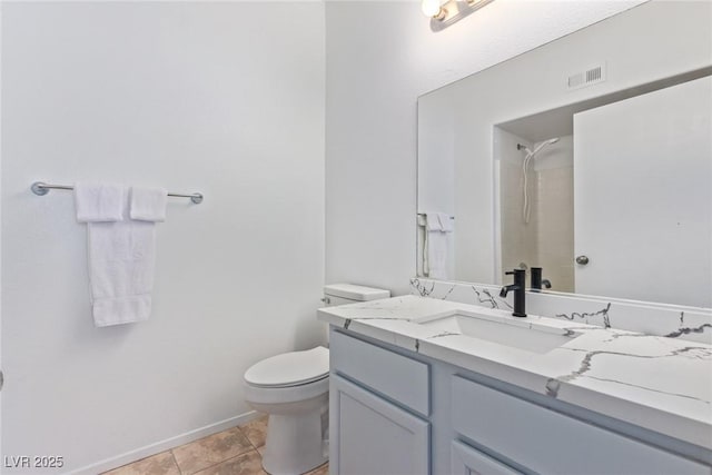 bathroom with vanity, tile patterned flooring, toilet, and a shower