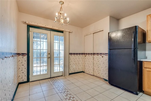 interior space featuring black refrigerator, decorative light fixtures, light tile patterned floors, a healthy amount of sunlight, and french doors