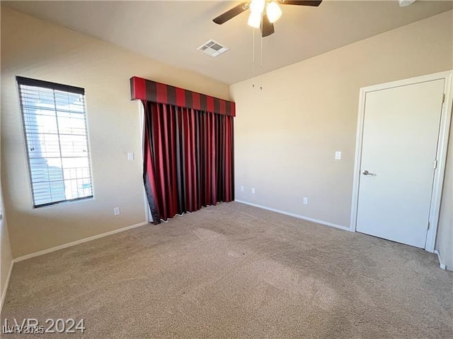 empty room featuring carpet floors and ceiling fan