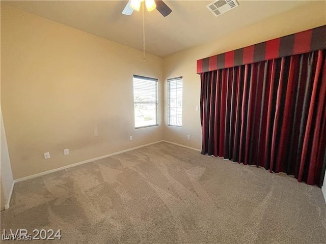 empty room featuring carpet, baseboards, ceiling fan, and visible vents