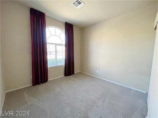 spare room with baseboards, visible vents, and carpet floors