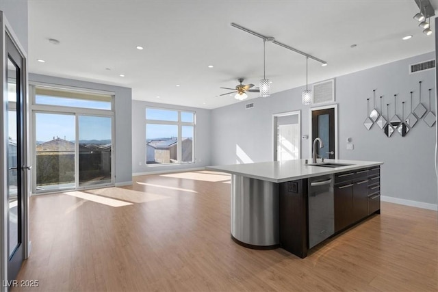 kitchen with sink, dishwasher, a kitchen island with sink, hanging light fixtures, and light hardwood / wood-style floors