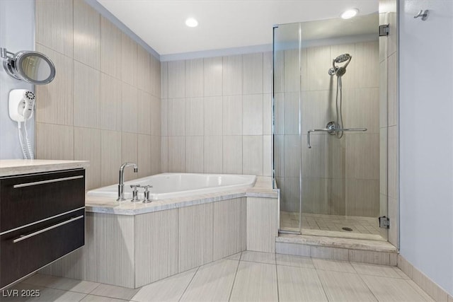 bathroom with vanity, independent shower and bath, tile patterned flooring, and tile walls