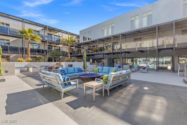 exterior space with an outdoor living space with a fire pit