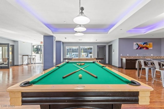 playroom with indoor bar, hardwood / wood-style floors, pool table, and a tray ceiling