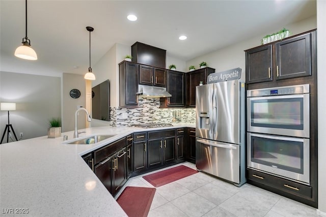 kitchen with decorative light fixtures, sink, decorative backsplash, dark brown cabinetry, and stainless steel appliances