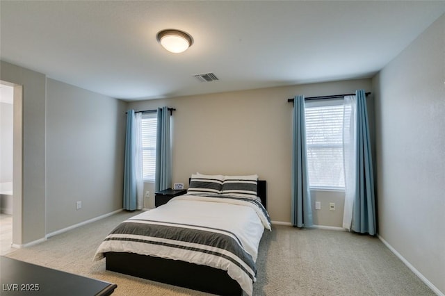 bedroom with multiple windows and light colored carpet