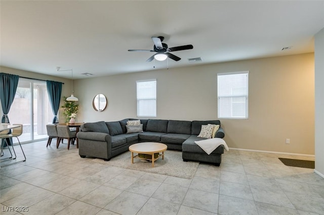 living room with light tile patterned floors, a wealth of natural light, and ceiling fan