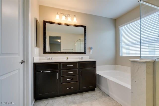 bathroom with a washtub, vanity, and tile patterned floors