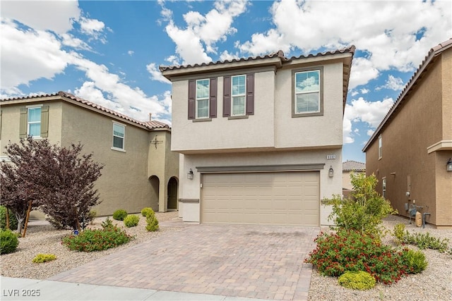 view of front facade with a garage, decorative driveway, and stucco siding