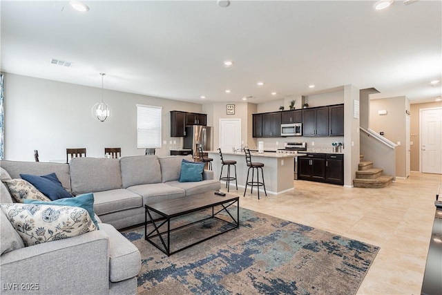 living room featuring light tile patterned floors, a chandelier, recessed lighting, visible vents, and stairs