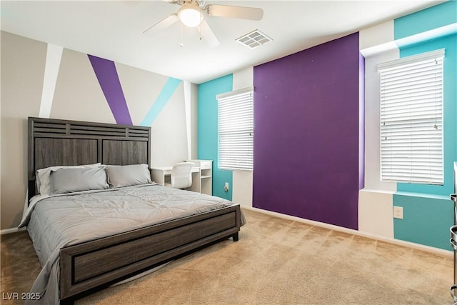 bedroom with light carpet, ceiling fan, visible vents, and baseboards