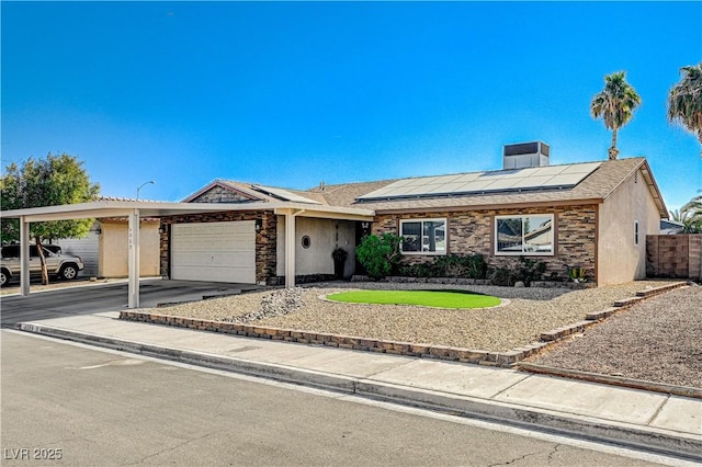 ranch-style home with a garage and solar panels